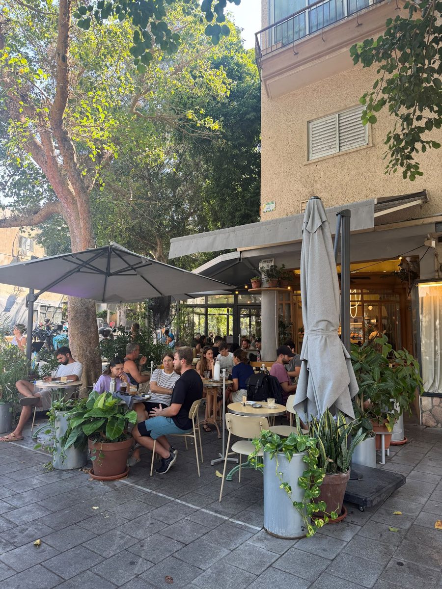 החזית של איזי קפה בקינג ג׳ורג׳ עם צמחים ושולחנות על המדרכה